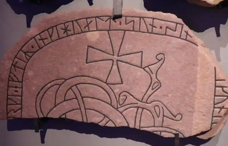 Rune stone with cross and inscription on the edge